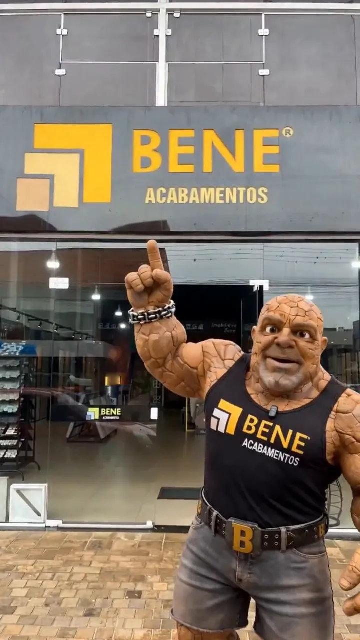 O personagem da Bene Acabamentos, com a camiseta da marca, em frente à fachada da loja